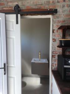 an open door with a table in a room with a brick wall at Harbour Garden in Mossel Bay +2 photos