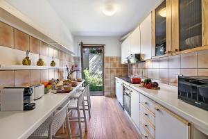 a kitchen with white counter tops and wooden cabinets at Il Giardino di Riva - Happy Rentals in Riva del Garda