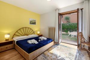 a bedroom with a bed with towels on it at Il Giardino di Riva - Happy Rentals in Riva del Garda