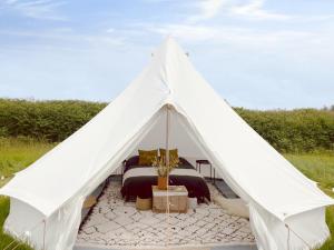 a white bell tent with a bed in it at The Rounds in Pembrokeshire