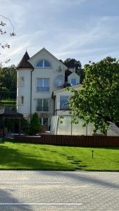 una grande casa bianca con un prato davanti di Vila pri kúpeľoch a Bojnice Altre 31 foto