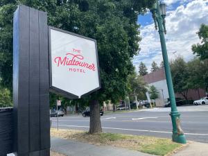 a sign for the millenium hotel next to a street at The Midtowner Hotel, SureStay Collection by Best Western in Sacramento