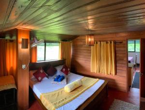 a bedroom with a bed in a wooden room at Cottage Home Belihuloya in Balangoda