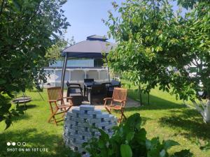 a table and chairs under an umbrella in a yard at Apartament u Małgosi in Kołczewo