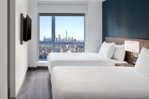 ニューヨークにあるHyatt Place New York Chelseaのベッドが2つと窓があるホテルの部屋