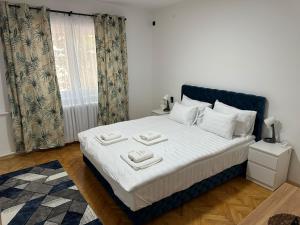 una camera da letto con un letto con lenzuola bianche e una finestra di M2-apartments a Kraljevo