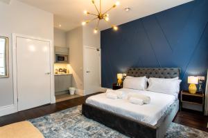 a bedroom with a large bed with a blue wall at Stay Coastal in Whitley Bay