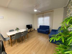 Una sala de estar con una mesa y un sofá azul. en BajoPlaya, en Burriana