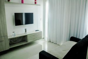 a living room with a tv and a couch at Apple Flat Natal in Natal