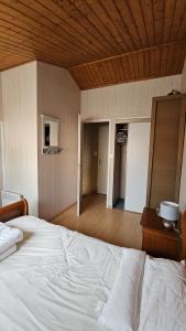 a bedroom with a white bed and a wooden ceiling at MAISON T2 WIFI Parking Privé Les Sables d'Olonne 9mn à Pied Plage Présidents in La Rudelière