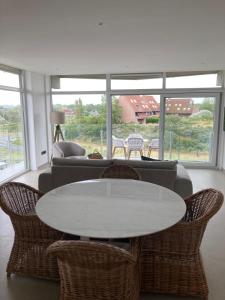 un salon avec un canapé, une table et des chaises dans l'établissement Casa Babette, à La Panne