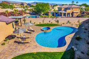 an overhead view of a pool with chairs and umbrellas at SPLASH-TASTIC FUN HOUSE in Indio