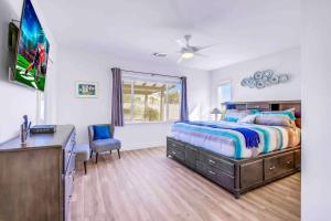 a bedroom with a bed and a tv and a desk at SPLASH-TASTIC FUN HOUSE in Indio +77 photos