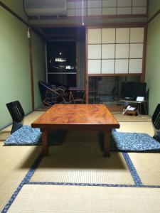 a wooden coffee table in a room with chairs at Miharaya Ryokan in Gujo
