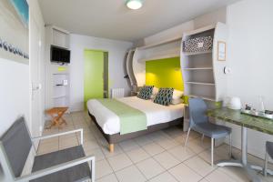 a hotel room with a bed and a desk at The Originals Boutique ,Hôtel de Ré in Sainte-Marie-de-Ré