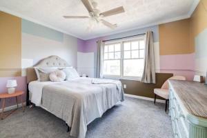 ein Schlafzimmer mit einem weißen Bett und einem Fenster in der Unterkunft Spacious House Near Savannah Airport - 5 BR in Savannah