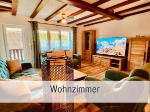 a living room with a couch and a tv at Kindertraum - Spielplatz - Spielzimmer - Terrasse mit Grill - Garten - wandern - 3 Schlafzimmer bis 9 Personen - Ferienhaus Taufstein 2 in Herbstein