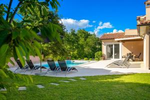 a yard with chairs and a swimming pool at Villa Emili by IstriaLux in Svetvinčenat