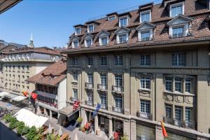 un gran edificio con un hotel en una calle de la ciudad en NH Bern The Bristol, en Berna