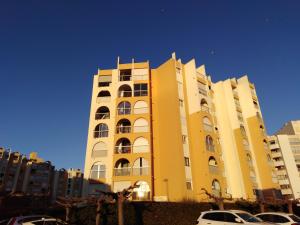 a yellow building with cars parked in front of it at STUDIO PROCHE MER ETANGS ET CANAUX in Mauguio