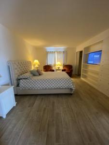 a bedroom with a bed and a flat screen tv at La Mesa House, a large modern home in Santa Barbara