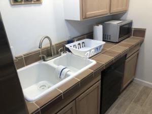 a kitchen counter with a sink and a microwave at La Mesa House, a large modern home in Santa Barbara +81 photos
