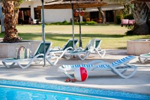 un grupo de tumbonas y una piscina en Leonardo Inn Hotel Dead Sea en Ein Bokek