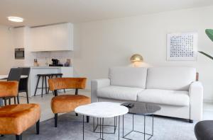 een woonkamer met een bank en een tafel bij Leader De Haan - Casselbergh Residences in De Haan