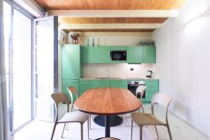 a kitchen with green cabinets and a wooden table at PrimoPiano - Zumbini G in Milan