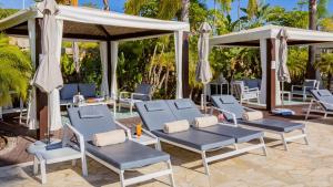 a group of chairs and umbrellas next to a pool at Conrad Algarve in Quinta do Lago