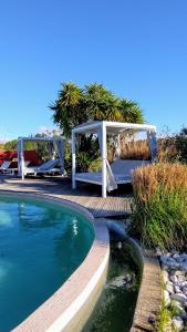 a swimming pool with a table and a picnic table next to a table at Gite L olivier in Baho