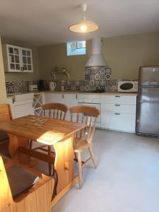 a kitchen with a wooden table and chairs at Maison de campagne in Lindry