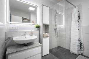 a white bathroom with a sink and a shower at Ferienwohnung Yacht & Meer in Bad Zwischenahn +9 photos