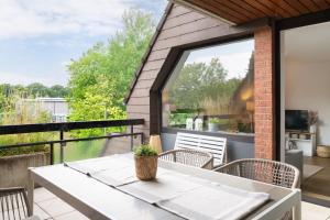 a patio with a table and chairs on a balcony at Ferienwohnung Yacht & Meer in Bad Zwischenahn