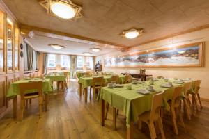 a dining room with green tables and chairs at Hotel Bouton d'Or - Courmayeur in Courmayeur
