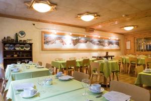 a dining room with tables and chairs with green linens at Hotel Bouton d'Or - Courmayeur in Courmayeur +37 photos