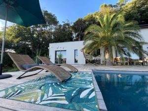 - une piscine avec 2 chaises et un parasol dans l'établissement Superbe villa panoramic Provence, à Montélimar