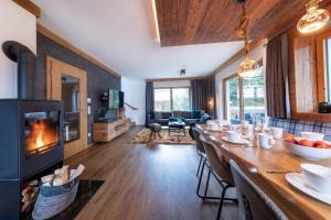 a living room with a long table and a fireplace at Chalet Zillertal Arena 1 in Kirchdorf