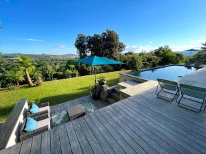 une terrasse avec une table, des chaises et un parasol dans l'établissement Superbe villa panoramic Provence, à Montélimar