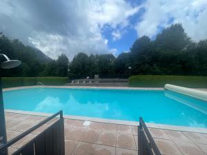 a large blue swimming pool with mountains in the background at Studio 1 personne Hedi 4 in Megève