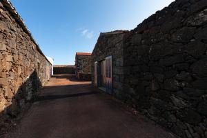 an alley in a stone wall with a gate at Adega Menezes in Lajido