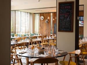 a restaurant with tables and chairs and a chalkboard at ibis Dijon Gare in Dijon