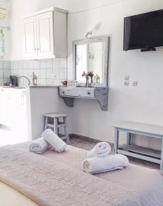 a white kitchen with two towels on two beds at Voula Accommodation in Agios Georgios