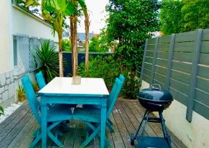 a blue table and chairs and a grill on a patio at Maison de ville idéalement placée in Tours