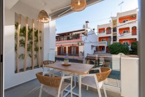 a balcony with a wooden table and chairs at IOSIF LUXURY ROOMS CENTER in Neos Marmaras