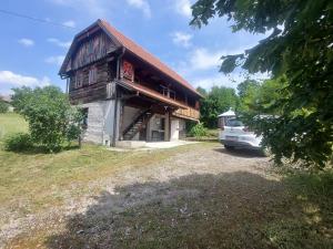 ein Haus mit einem davor geparkten Auto in der Unterkunft Old Style in Vukšin Šipak