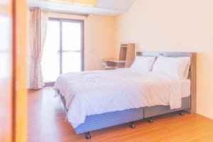 Ένα ή περισσότερα κρεβάτια σε δωμάτιο στο 頭城遊龍戲鳳賞鯨會館