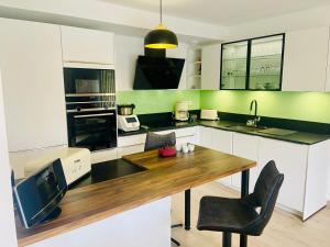 a kitchen with a wooden table and a television at Taylor - 2 pers - Appartement Dinan in Dinan