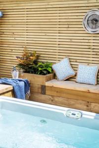 a bath tub with two pillows on a wooden wall at Laburnum Cottage Lanchester- Escape Beyond Holiday Lets in Lanchester