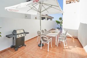 a table with an umbrella and a grill on a patio at Villa Pura - Private Jacuzzi & Heated Pool in Nerja